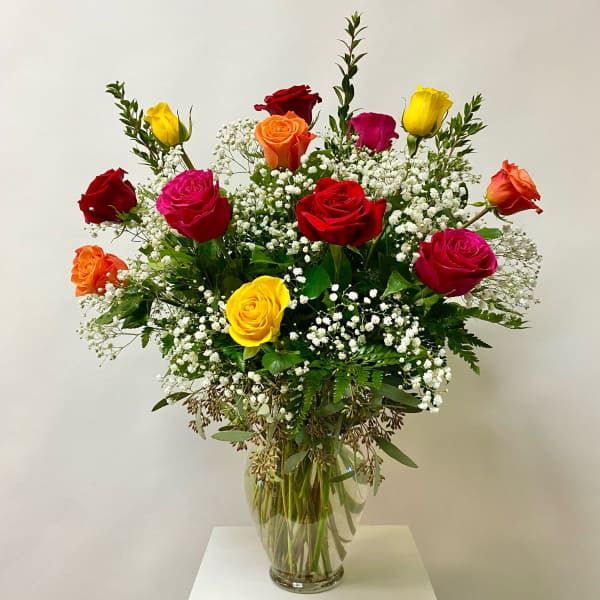 Mixed roses in a clear glass vase with baby's breath