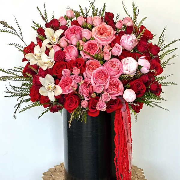 Large bouquet of pink and red roses in a black vase