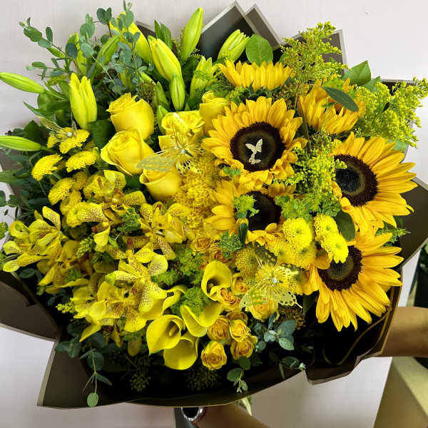 Yellow bouquet with sunflowers, roses, lilies, and orchids