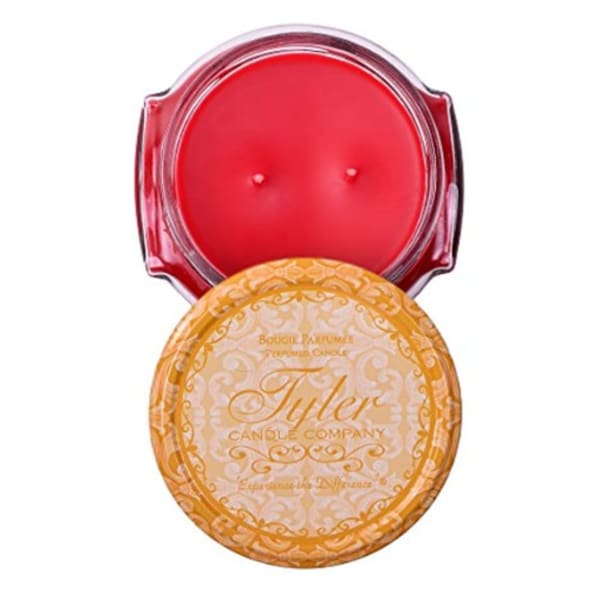 Two round candles in decorative tins, one red and one gold