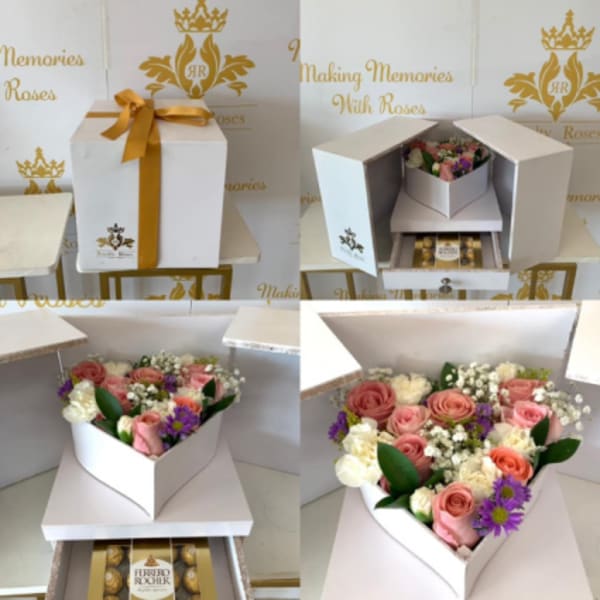 White gift box with pink and white roses and chocolates inside