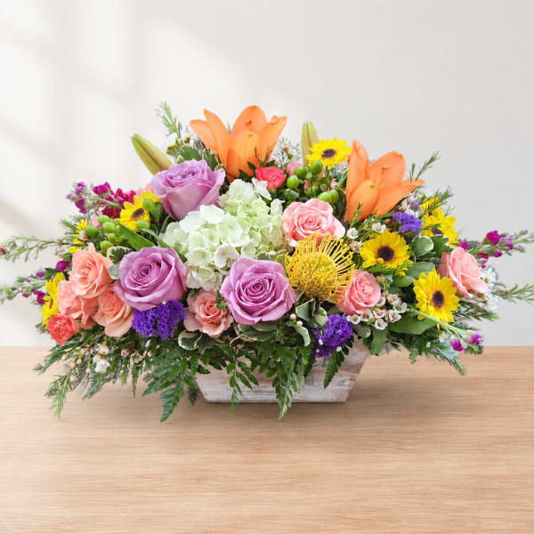 Colorful mixed flower arrangement in a low rectangular container