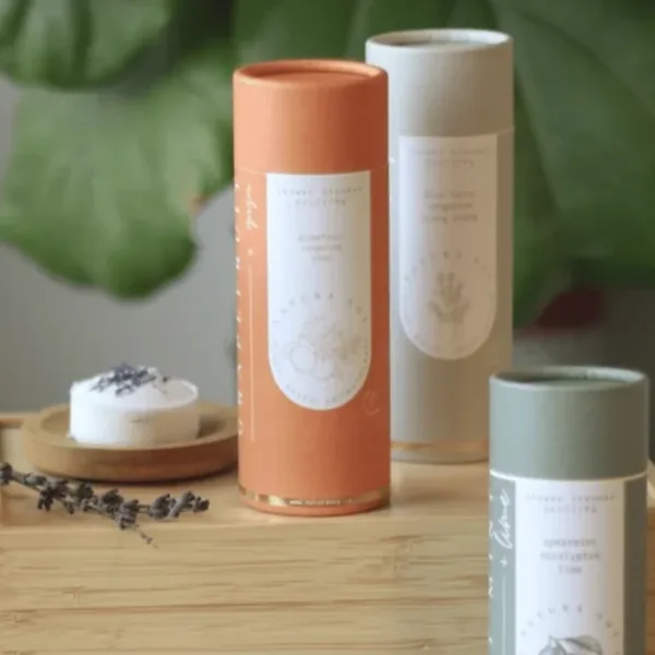 Assorted cylindrical candle tubes on a wooden surface with a small candle dish