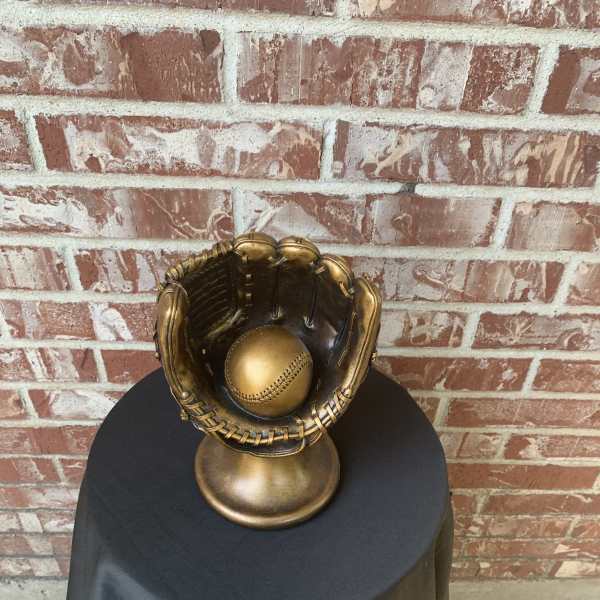 Gold baseball glove sculpture with a ball inside