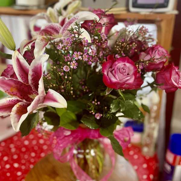 Bouquet of pink roses and white lilies in a glass vase