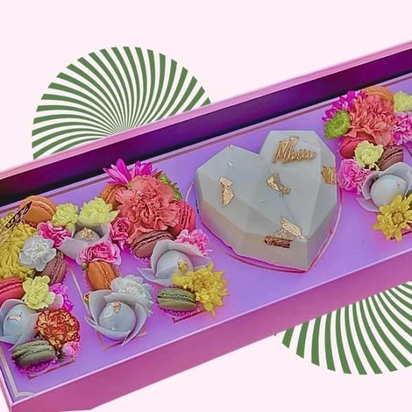 Heart-shaped gift box with colorful flowers and macarons
