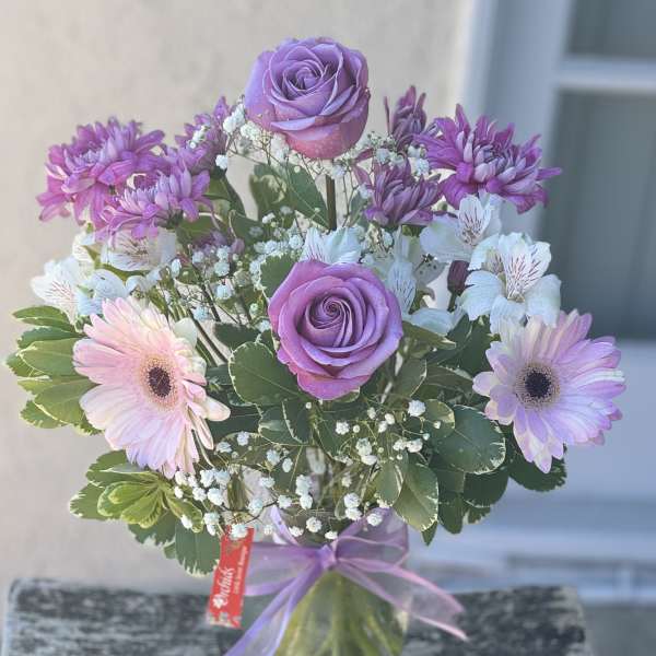 Lavender roses and pink gerbera daisies in a glass vase