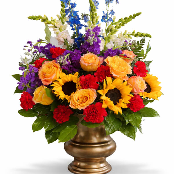 Colorful mixed flower arrangement in a gold vase