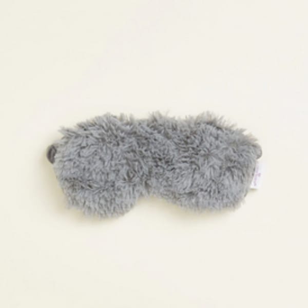 Gray fuzzy plush eye mask on a light background