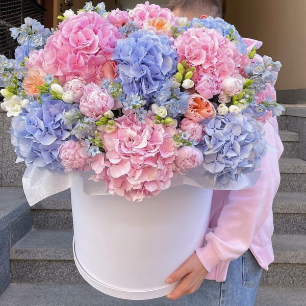 Large pastel bouquet in a white hatbox with pink and blue blooms
