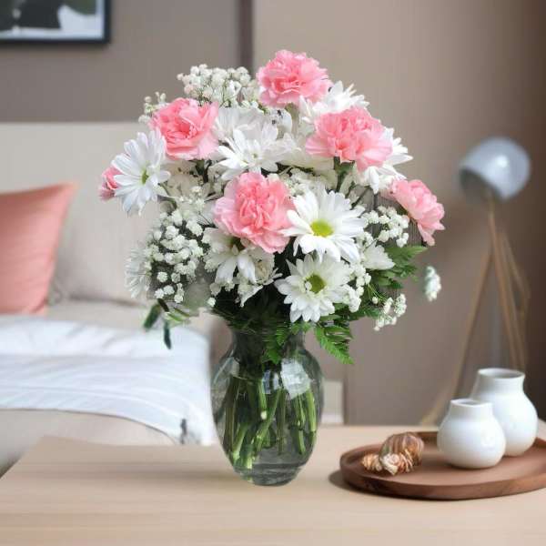 Pink carnations and white daisies in a glass vase