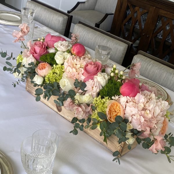 Low floral centerpiece with pink and cream roses in a wooden box