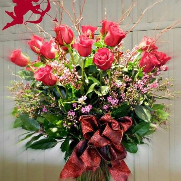 Bouquet of red roses with a large ribbon in a glass vase