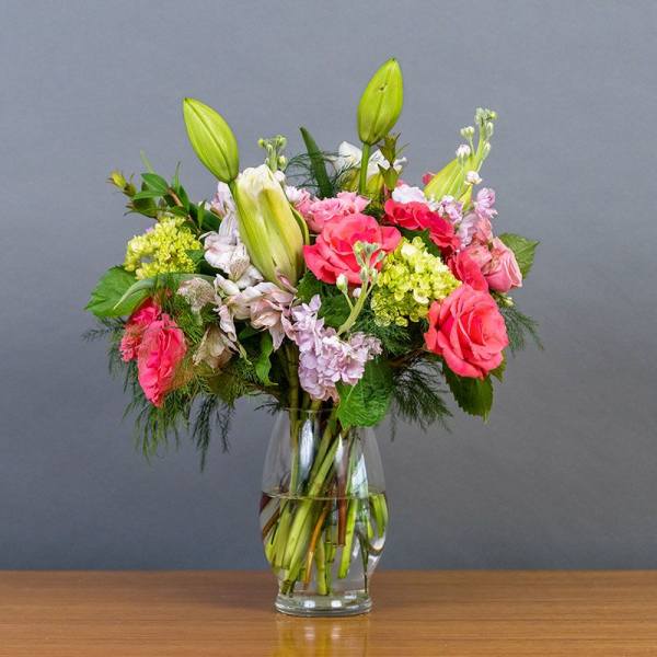 Bouquet of pink roses and lilies in a clear glass vase