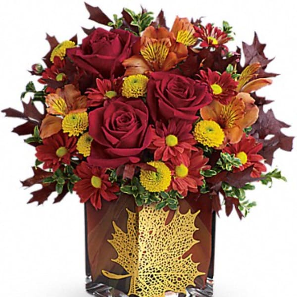 Autumn bouquet of red roses and mums in a decorative vase