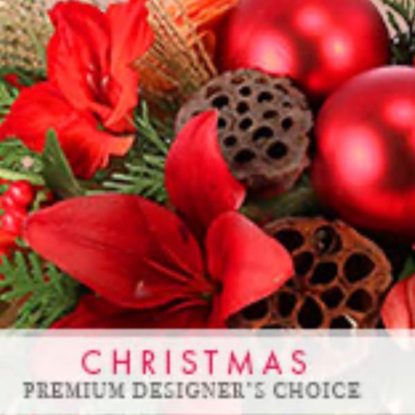 Red holiday floral arrangement with ornaments and pinecones
