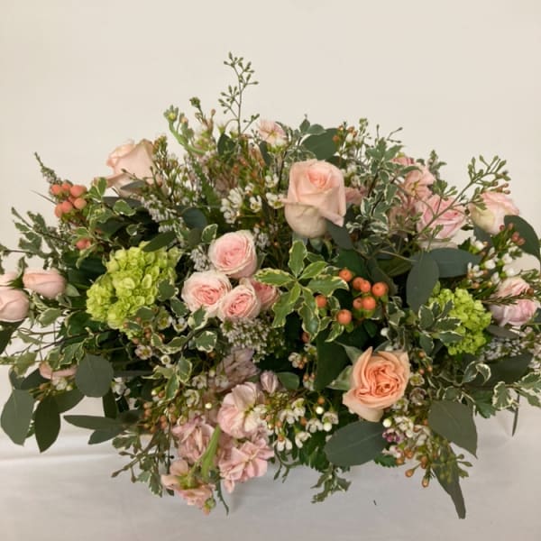 Blush roses and green hydrangeas in a low, lush bouquet
