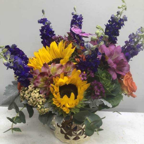 Colorful bouquet with sunflowers, purple blooms, and pink flowers in a gold vase