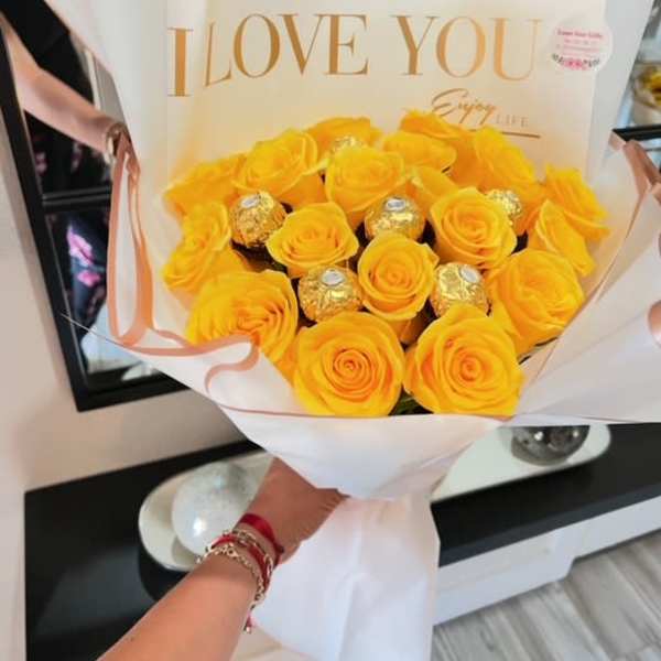 Yellow rose bouquet with gold-wrapped chocolates in white and peach wrapping