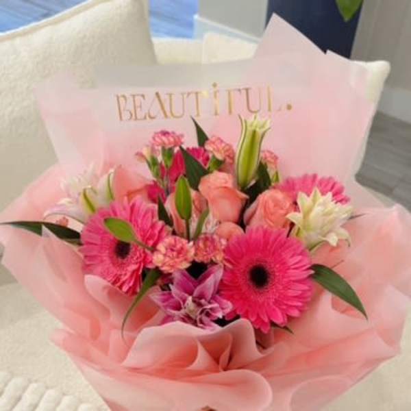 Pink mixed flower bouquet wrapped in pale pink paper