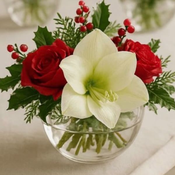 Red roses and a white amaryllis in a clear glass bowl