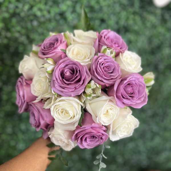 Bouquet of lavender and white roses held in hand