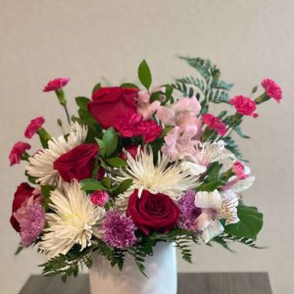 Pink and red flower arrangement in a white vase