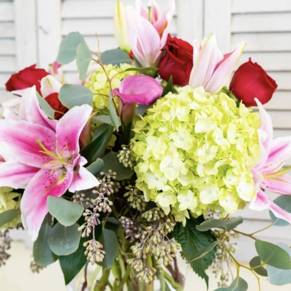 Bouquet of pink lilies, red roses, and green hydrangeas