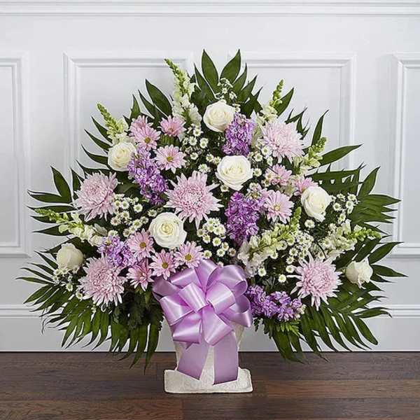 Standing floral spray with pink and white flowers and a lavender ribbon