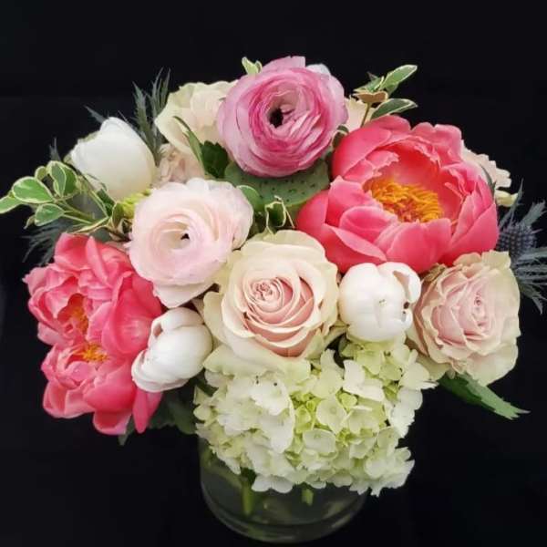 Pink and white flowers arranged in a glass vase