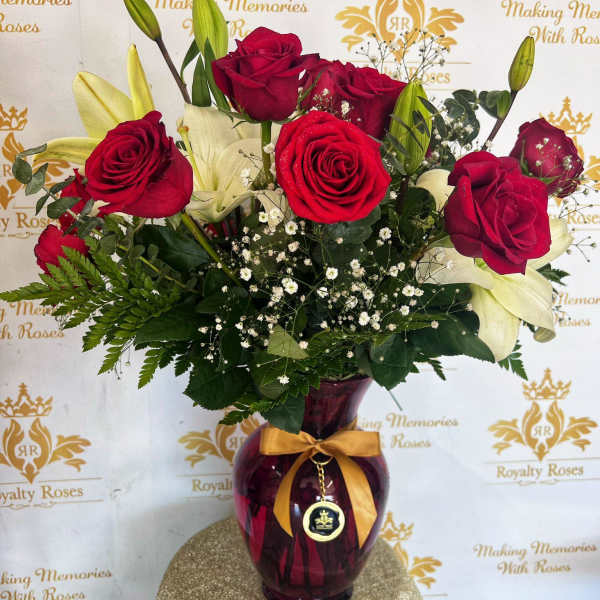 Bouquet of red roses and white lilies in a purple glass vase