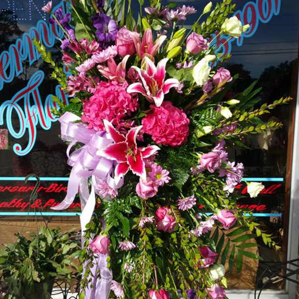 Tall standing floral spray with pink and white blooms on an easel