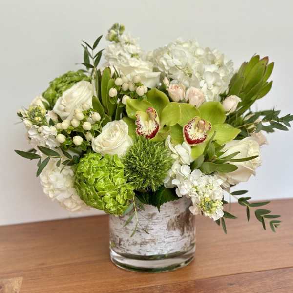 White and green floral arrangement in a glass vase