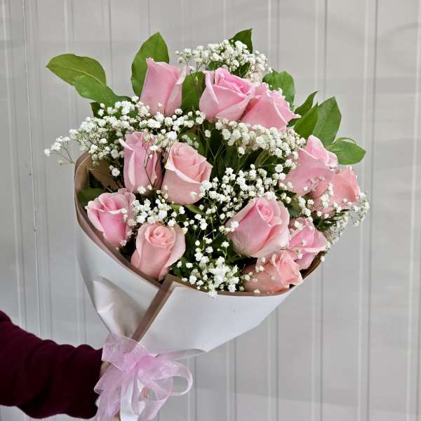 Bouquet of pink roses with white baby's breath in white wrap