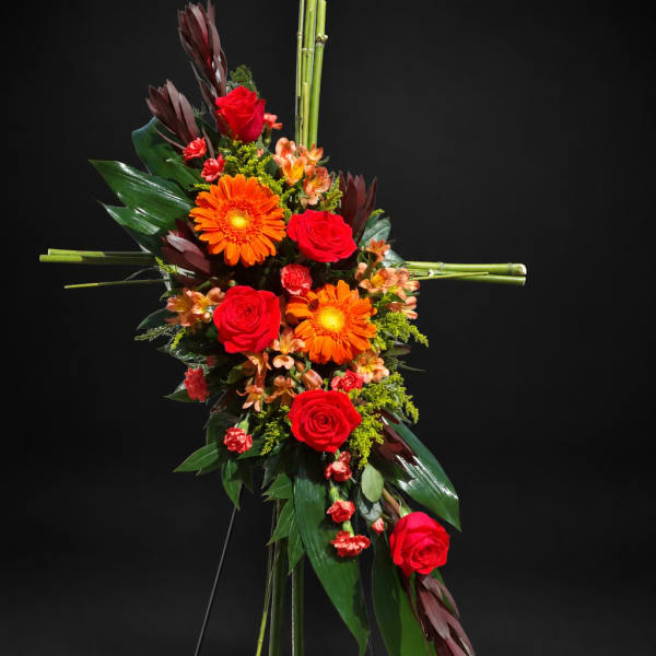Tall floral standing arrangement with red roses and orange gerbera daisies