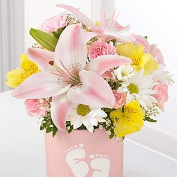 Pink and yellow flower arrangement in a pink box with baby footprints