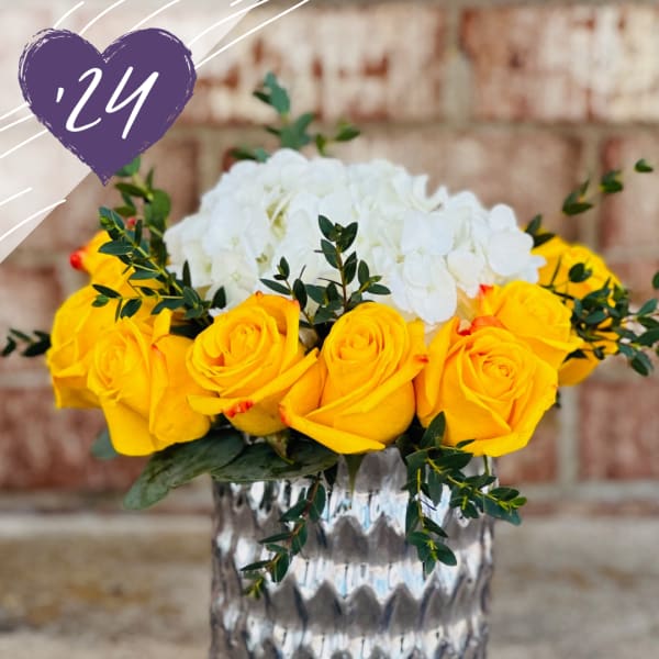 Yellow roses and white hydrangeas in a silver vase