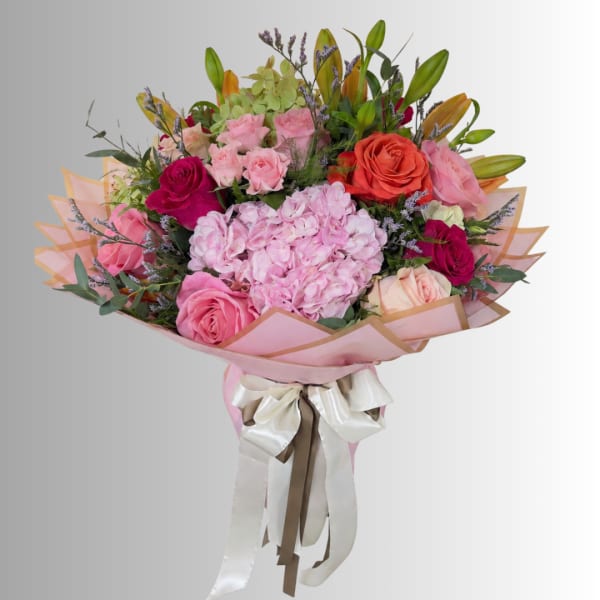 Large bouquet of pink and coral roses with a pink hydrangea center