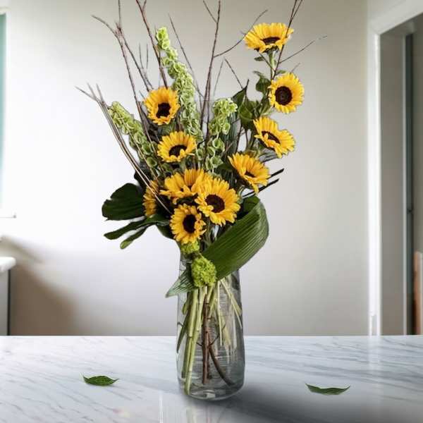Tall sunflower arrangement in a clear glass vase