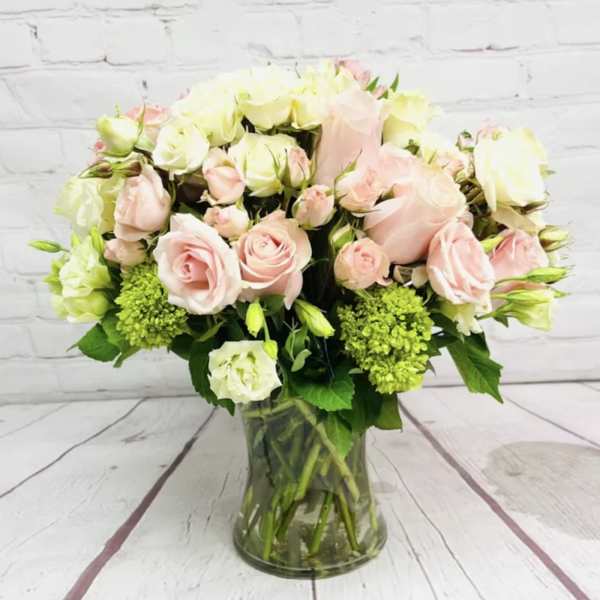 Pink and white roses arranged in a glass vase