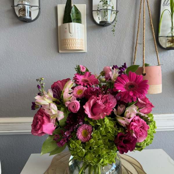 Pink and magenta flower arrangement in a glass vase