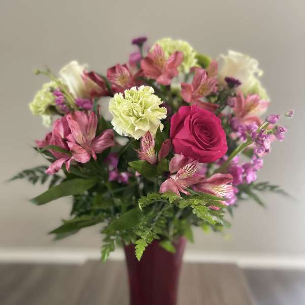 Pink and white mixed bouquet in a burgundy vase