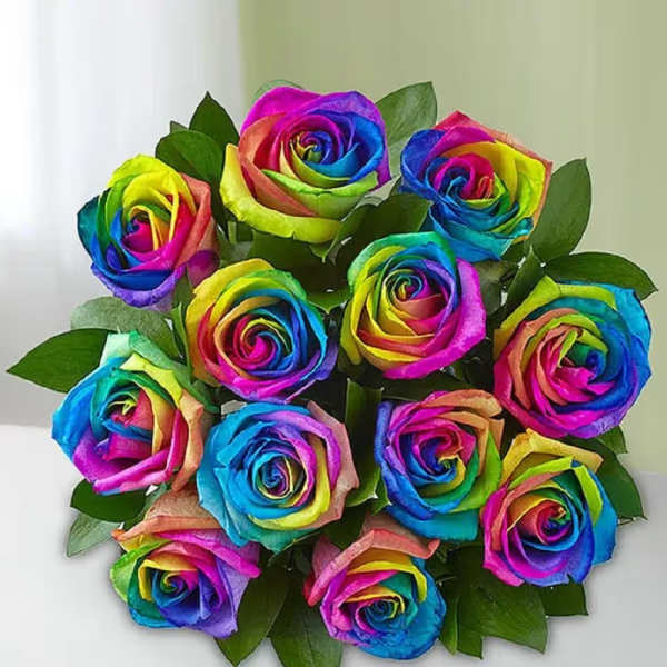 Bouquet of rainbow-colored roses with green leaves