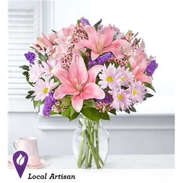Pink lilies and daisies in a clear glass vase