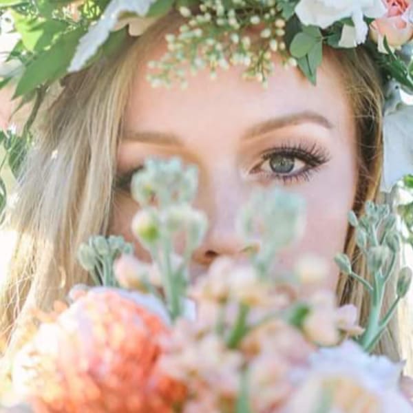 Woman wearing a floral crown and holding a pastel bouquet