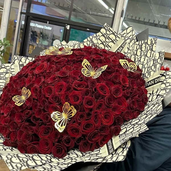 Large bouquet of deep red roses with decorative butterfly picks