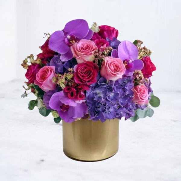 Pink and purple flower arrangement in a gold vase