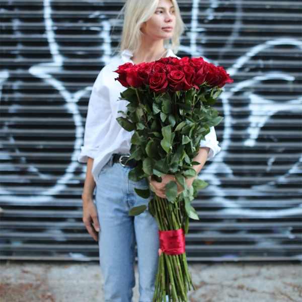 Woman holding a large bouquet of red roses