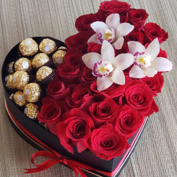Heart-shaped box with red roses, white orchids, and gold-wrapped chocolates