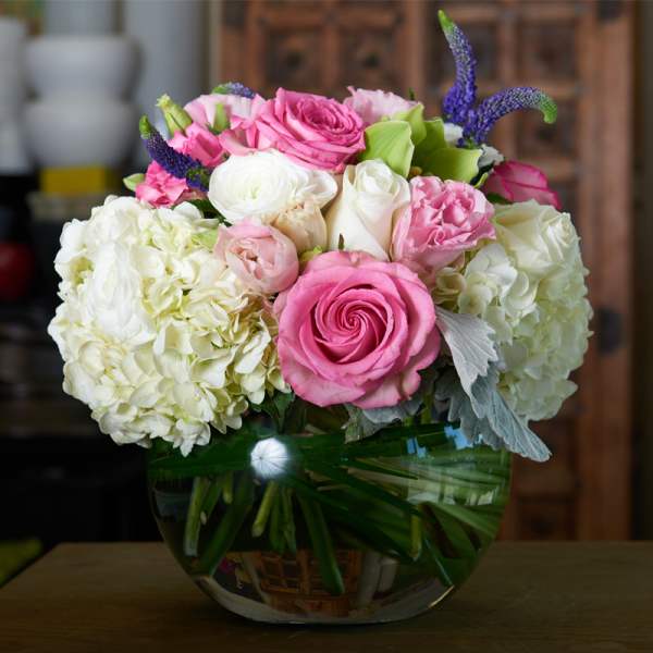 Pink and white roses with hydrangeas in a glass vase